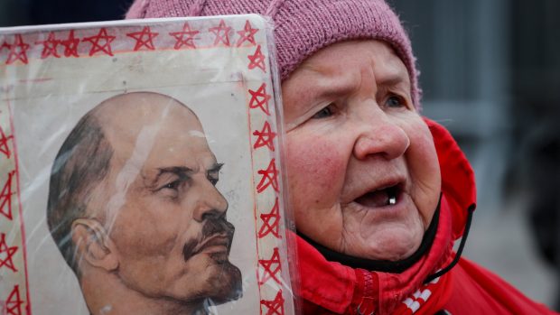 Ruská žena s podobiznou Vladimíra Iljiče Lenina na Rudém náměstí v Moskvě