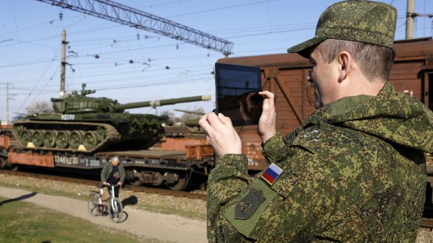 Ruský důstojník fotí vlak s vojenskou technikou
