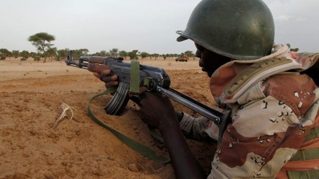 Nigerský voják se zbraní namířenou k hranici se sousední Nigérií nedaleko města Diffa