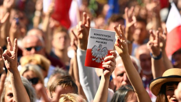 Lidí držící výtisk ústavy na demonstraci proti zásahům vládní strany Právo a spravedlnost do polského nejvyššího soudu.