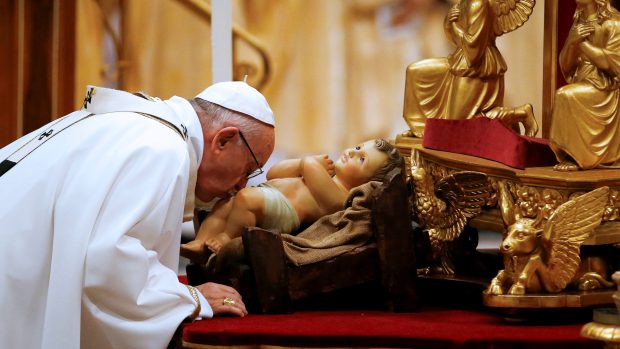Papež František líbí sochu Ježíška v bazilice svatého Petra ve Vatikánu.