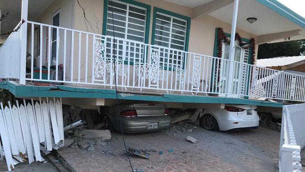 Auta uvězněná pod domem poničeném zemětřesením