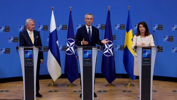 Finský ministr zahraničí Pekka Haavisto (zleva), generální tajemník NATO Jens Stoltenberg a švédská ministryně zahraničí Ann Lindeová na tiskové konferenci k podepsání protokolu o přistoupení do NATO.