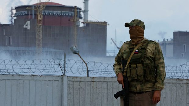 Voják s ruskou vlajkou poblíž Záporožské jaderné elektrárny