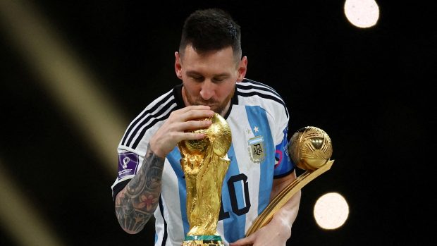 Lionel Messi s trofejí pro mistra světa a s trofejí pro nejlepšího hráče turnaje