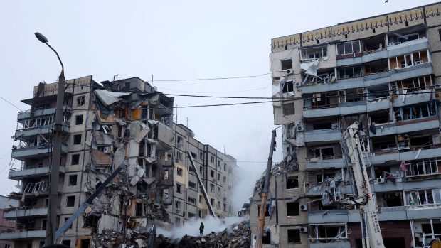 Práce záchranných složek potom, co obytný dům v ukrajinském Dnipru zasáhla ruská raketa