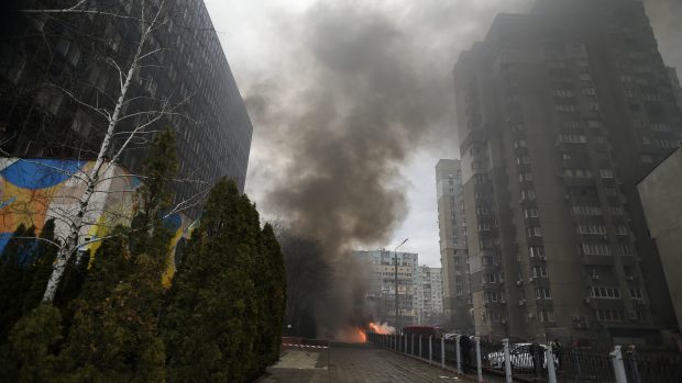 Kouř a požár způsobený troskami rakety, které dopadly na nádvoří obytného domu v Kyjevské oblasti