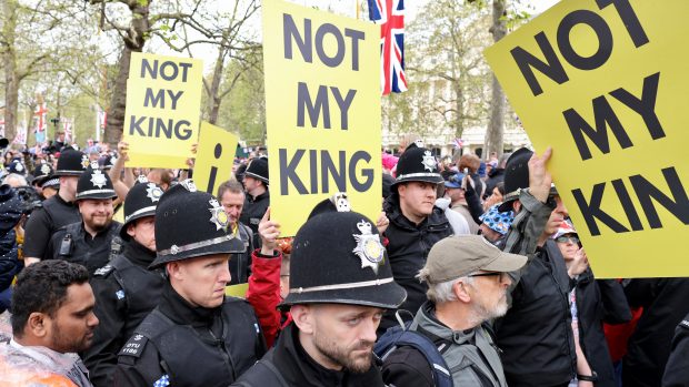 Policisté v okolí hlavní třídy The Mall odvádějí protestující proti monarchii, kteří nesou transparenty s nápisem: „Není můj král“