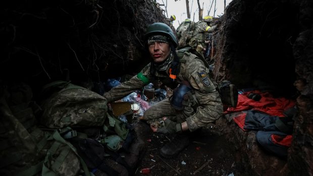 Ukrajinský voják odpočívá po boji poblíž Bachmutu
