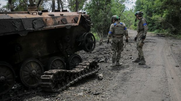 Příslušníci ukrajinské armády kontrolují zničené ruské bojové vozidlo pěchoty BMP-2 poblíž frontové linie v Doněcké oblasti na Ukrajině