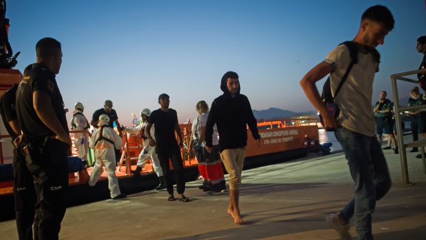 Migranti, kteří byli zachráněni z člunu ve Středozemním moři, vystupují ze španělského záchranného plavidla po jejich příjezdu do přístavu Malaga
