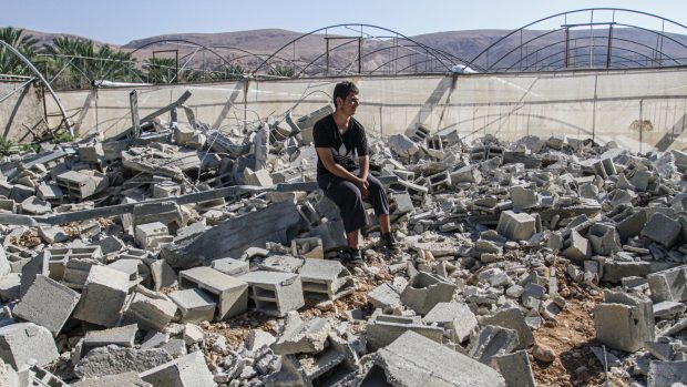 Palestinec sedí v ruinách svého domu na Západním břehu Jordánu