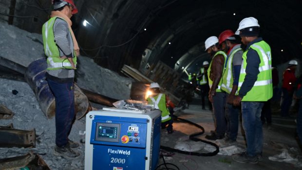 Záchranáři opravují stroj v tunelu, kde uvízli dělníci