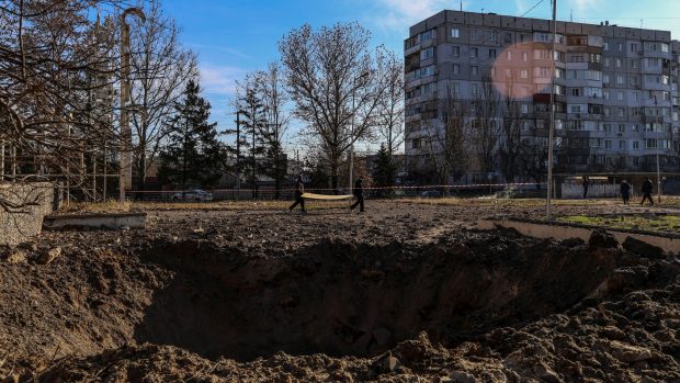Kráter po dopadu ruské střely v ukrajinském Chersonu