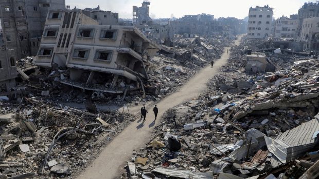 Palestinci procházejí zničeným městem Džabálijá na serveru Pásma Gazy (fotografie z 22. února 2024)