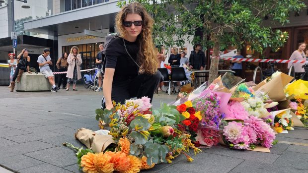 Žena pokládá květiny po sobotním útoku v Sydney