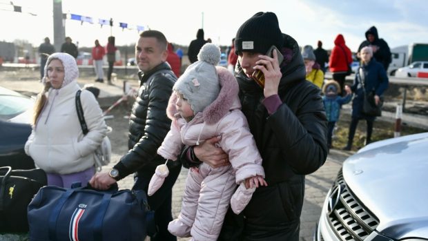 Ukrajinci prchají přes hraniční přechod u polské Medyky. Někteří nechávají auta na ukrajinském území a dál pokračují pěšky s dětmi v náručí