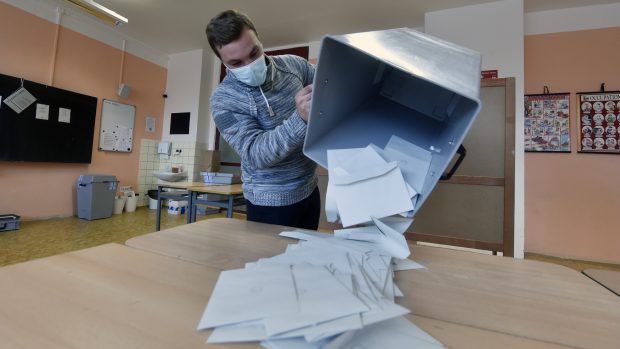 Člen volební komise sype obálky z urny 10. října 2020 v Základní škole Josefa Valčíka v Ostravě po skončení 2. kola senátních voleb