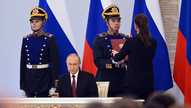 Vladimir Putin při ceremoniálním podepisování dokumentů o připojení ukrajinského území k Rusku