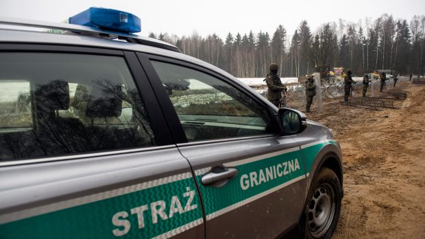 Ozbrojení členové pohraniční stráže hlídají polskou hranici s Běloruskem během jejího zabezpečování