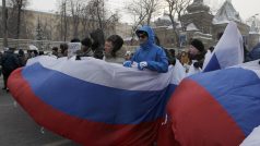Pochodující odpůrci Vladimira Putina nesou ruskou vlajku