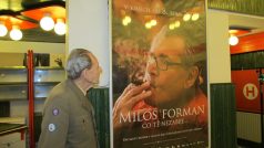 Jeden z pamětníků si prohlíží plakát, na kterém je Miloš Forman