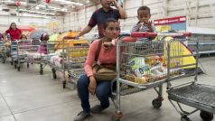 Venezuelští zákazníci se potýkají s nedostatkem zboží, na snímku čekají ve frontě uvnitř supermarketu v Caracasu