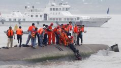 Záchranáři pomáhají pasažérům, kteří byli uvezněni v trupu lodi