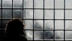 Žena čeká v teple nádraží v newyorském Queens a prohlíží si námrazu na okenních tabulkách