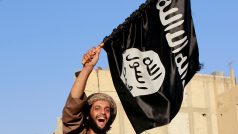 Bojovník mává vlajkou Islámského státu při přehlídce v Rakce (archivní foto)