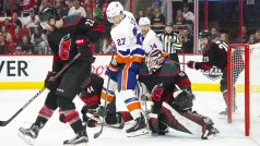 Gólman Caroliny Hurricanes Curtis McElhinney si snaží najít prostor, aby viděl na puk ve třetím zápase druhého kola play-off NHL proti New Yorku Islanders