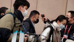 Novináři v Pekingu procházejí před vstupem na tiskovou konferenci kontrolou, během které jim je měřena teplota. Jedním z příznaků nemoci, kterou způsobuje nový koronavirus, je totiž zvýšená teplota.