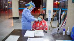 Zdravotní sestra měří teplotu ženě, která přišla do nemocnice ve městě Jüe-jang.