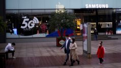 Lidé s rouškami před prodejnou elektroniky Samsung.