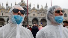 Někteří návštěvníci na náměstí sv. Marka se oblékli do ochranných obleků. Sever Itálie hlásí největší počet nakažených koronavirem v Evropě.