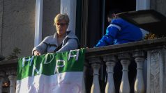 Žena vyvěsila na balkon vlajku s nápisem, že zase bude dobře.