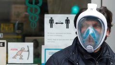 Muž v potápěčské masce stojí před lékárnou v Římě během karanténních opatření.