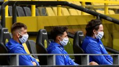Hráči FC Schalke 04, kteří se kvůli povinným rozestupům nevešeli na lavičku náhradníků, a tak sledovali utkání z tribuny
