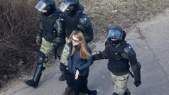 Běloruské bezpečnostní složky zadržují ženu při protestu v Minsku.