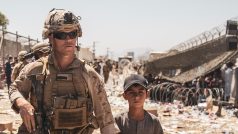 Americký mariňák odvádí na kábulském letišti chlapce k jeho rodině