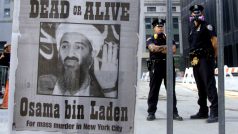 Policisté stojí vedle plakátu, na kterém je vyhlášeno pátrání po Usámu bin Ládinovi