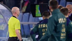 Rozhodčí kontroluje video během fotbalového zápasu