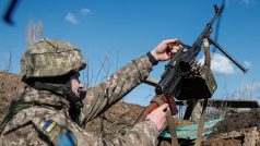 Ukrajinský voják upevňuje v zákopu kulomet