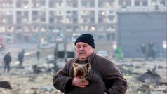 Muž se psem na místě bombardováním poničeného nákupního centra v Kyjevě