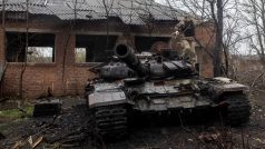 Ukrajinský voják seskakuje ze zničeného ruského tanku ve vesnici Mala Rogan na východě Ukrajiny