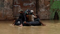 Dobrovolník pádluje na nafukovacím člunu při evakuaci oběti povodní po deštích a záplavách během monzunového období v Čarsada