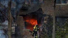 Hasič zasahující při požáru domu, který zasáhla raketa během útoku na Kyjev