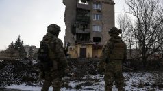 Ukrajinští vojáci před poškozeným domem v Bachmutu