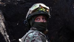 Ukrajinský voják poslouchá v zákopech u Bachmutu dělostřeleckou palbu