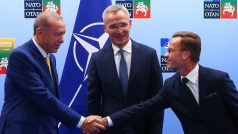 Turecký prezident Tayyip Erdogan a švédský premiér Ulf Kristersson si podávají ruce vedle generálního tajemníka NATO Jense Stoltenberga před jejich setkáním v předvečer summitu NATO ve Vilniusu